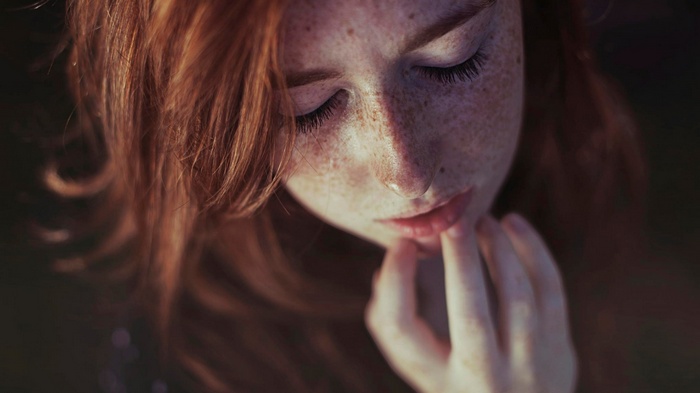 Close-up of a young woman with red hair and freckles