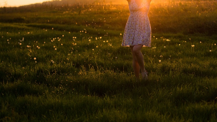Woman in a field at sunset with bokeh