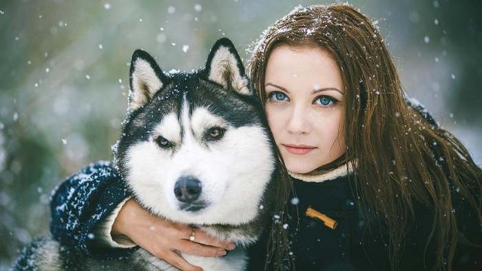 Woman hugging a Siberian Husky in the snow