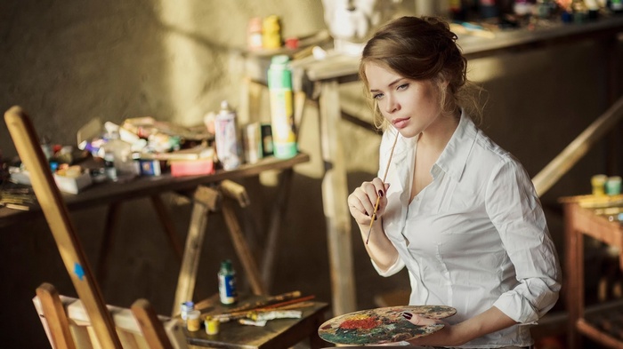 Woman painting with a palette and brush