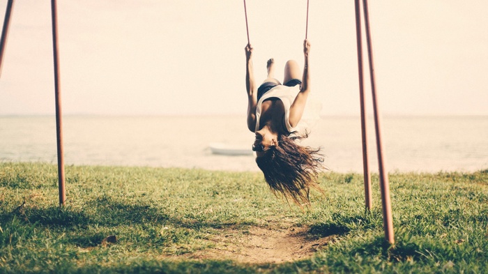 Woman swinging upside down outdoors