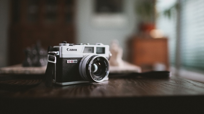 Canon G-III QL camera on a wooden surface