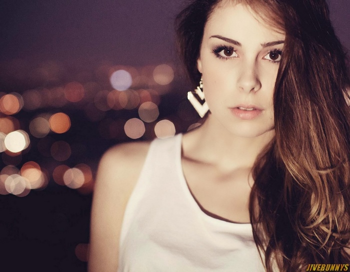 Lena Meyer-Landrut with wavy brown hair and large earrings