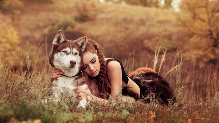 Woman hugging a Siberian Husky in a field
