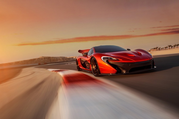 Red McLaren P1 driving on a race track at sunset