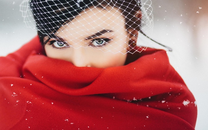 Woman in red scarf and veil in snow