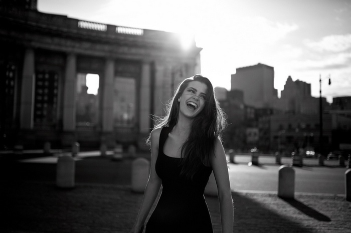 Woman laughing in front of a building