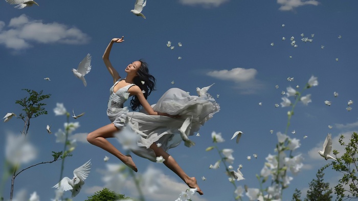 Asian woman dancing with doves in the sky