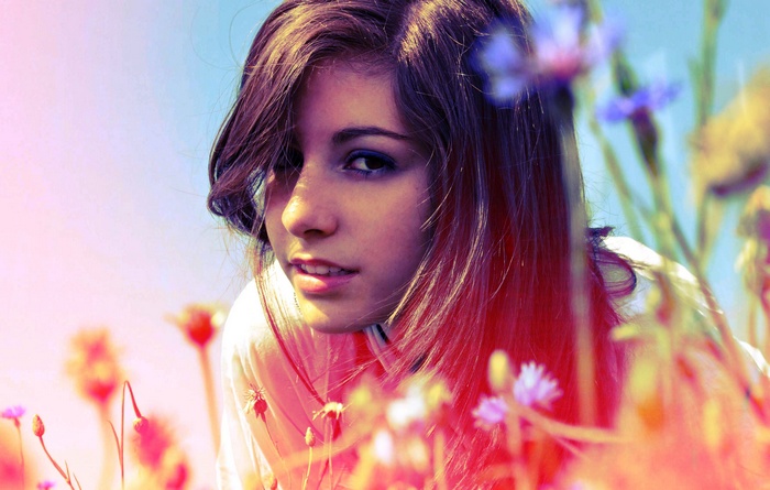 Young woman with brunette hair in a field of flowers