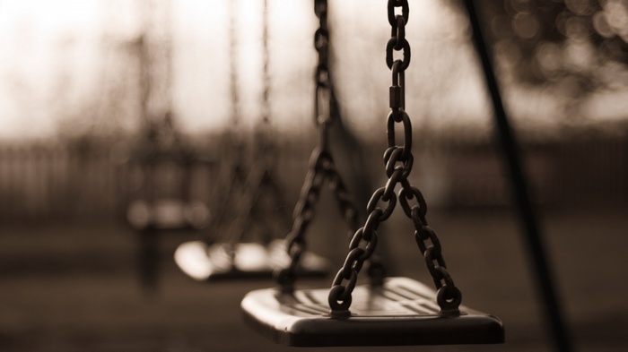 Sepia toned swings with chains and depth of field