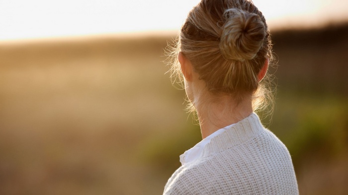 Woman with blonde hair in a bun outdoors