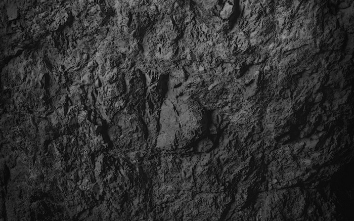 Close-up texture of rough, dark grey rock