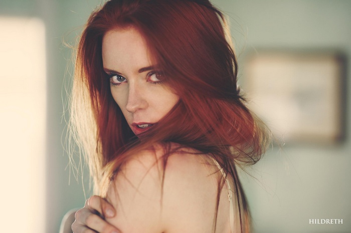 Woman with red hair looking over her shoulder