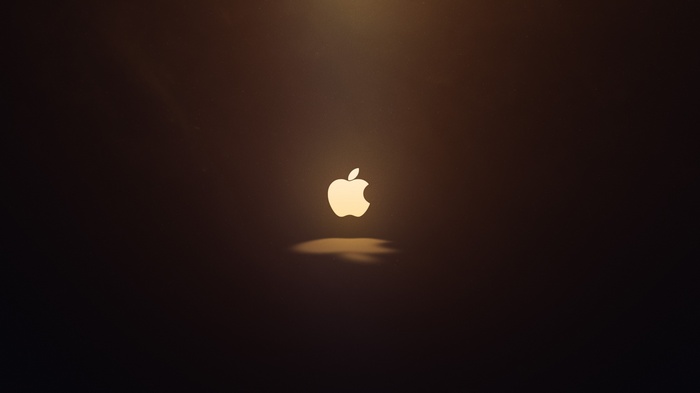 Apple logo illuminated against a dark background