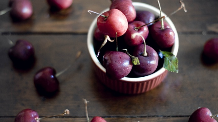 Cherries in a bowl on a wooden table