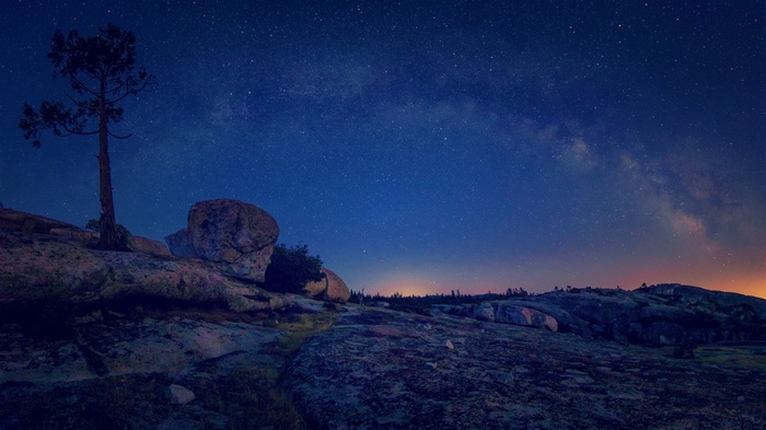 Night landscape with Milky Way and stars over rocks