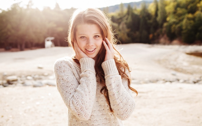 Young woman with hands on cheeks outdoors