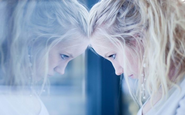 Blonde woman looking at her reflection