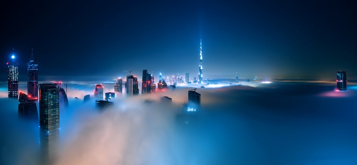 Dubai cityscape shrouded in mist at night with Burj Khalifa