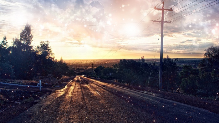 Road leading to sunset with power lines