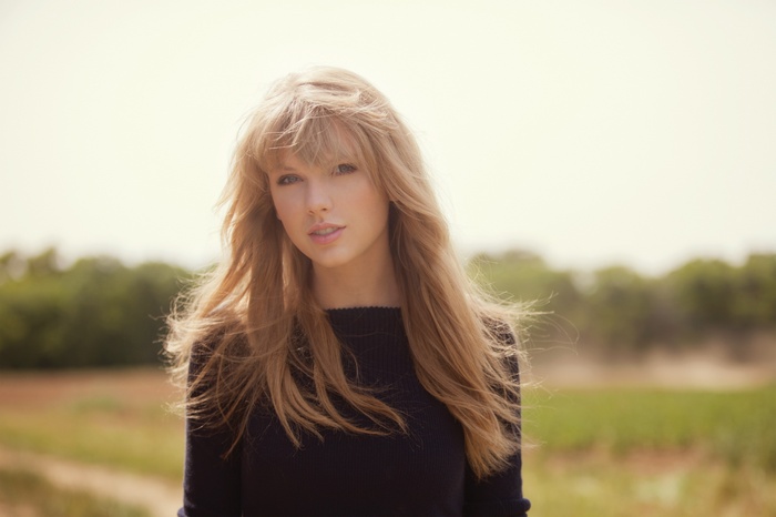 Taylor Swift in a dark sweater outdoors