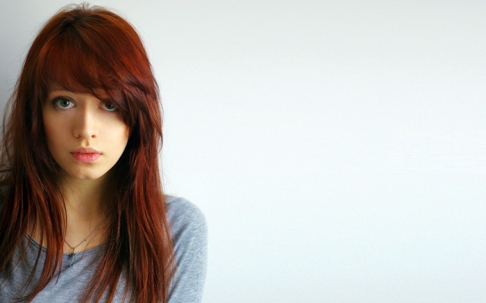 Redhead woman with bangs and a grey shirt