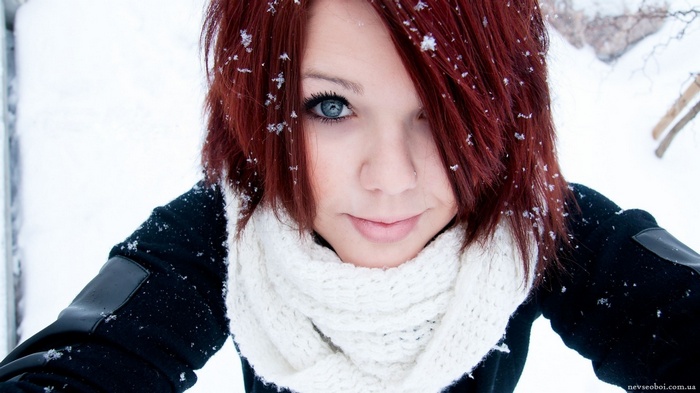 Redhead woman with blue eyes in the snow