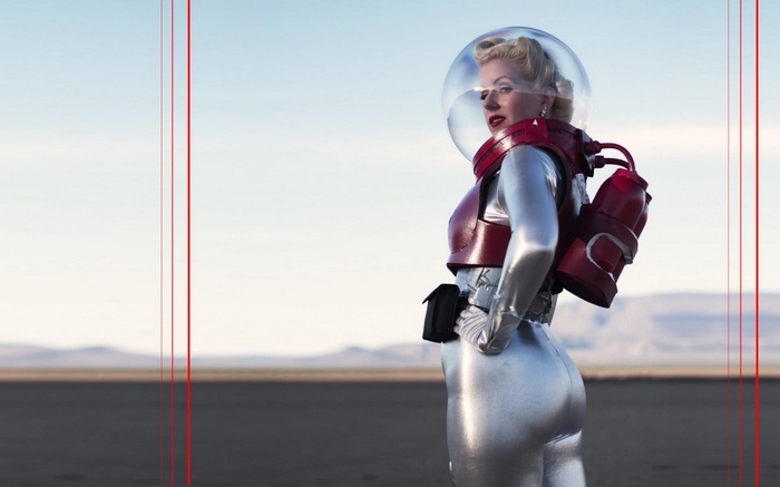 Woman in a retro-style silver spacesuit with a red helmet