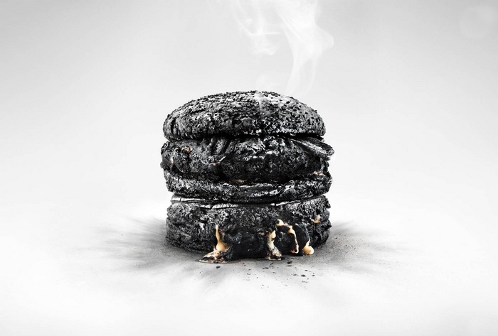Burnt hamburger with melting cheese and smoke
