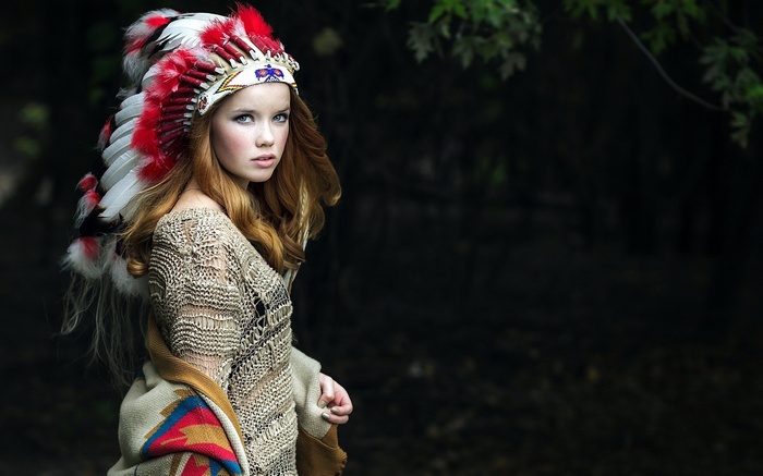 Woman wearing a Native American headdress outdoors