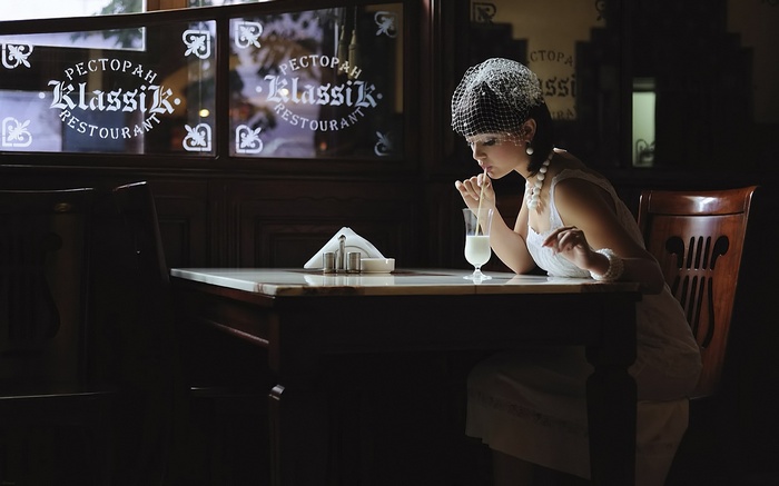 Woman in vintage attire drinking milk at Klassik Restaurant