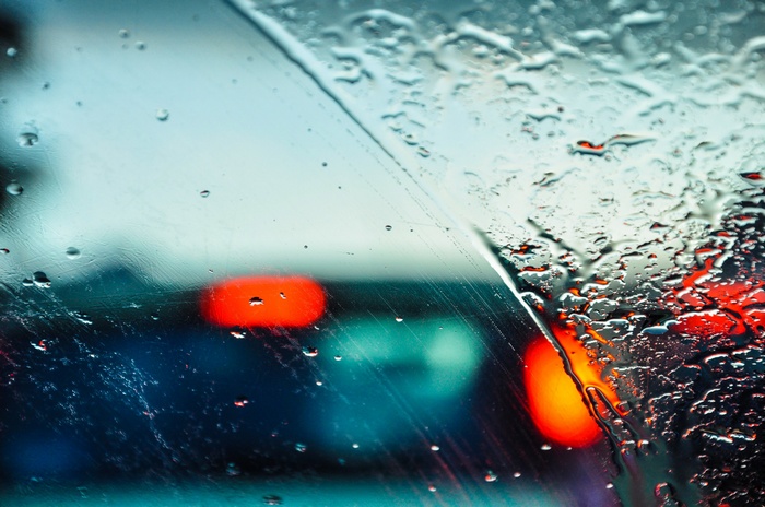 Raindrops on a car windshield with bokeh lights