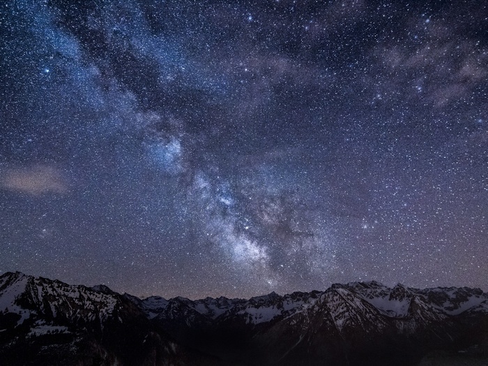 The Milky Way over snow-capped mountains