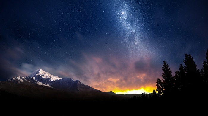 Snow-capped mountains under the Milky Way and trees