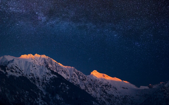 Milky Way over snow-capped mountains at night