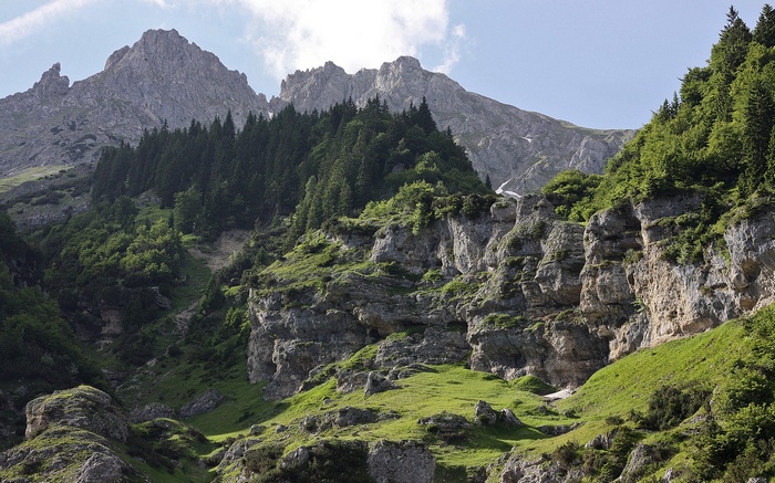 Mountain landscape with green slopes and rocky cliffs