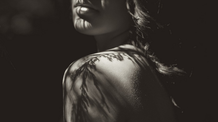 Monochrome portrait of a woman with shadows on her shoulders