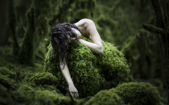 Woman covered in moss in a forest