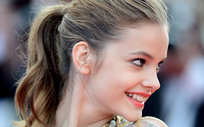 Barbara Palvin smiling in a ponytail, side view