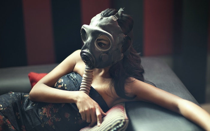Woman wearing a gas mask on a couch
