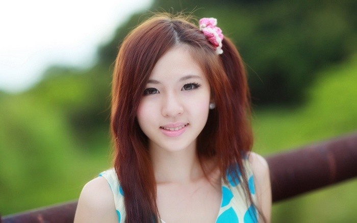 Young Asian woman with brown hair and a flower accessory