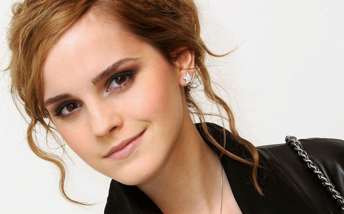 Emma Watson smiling with star earrings