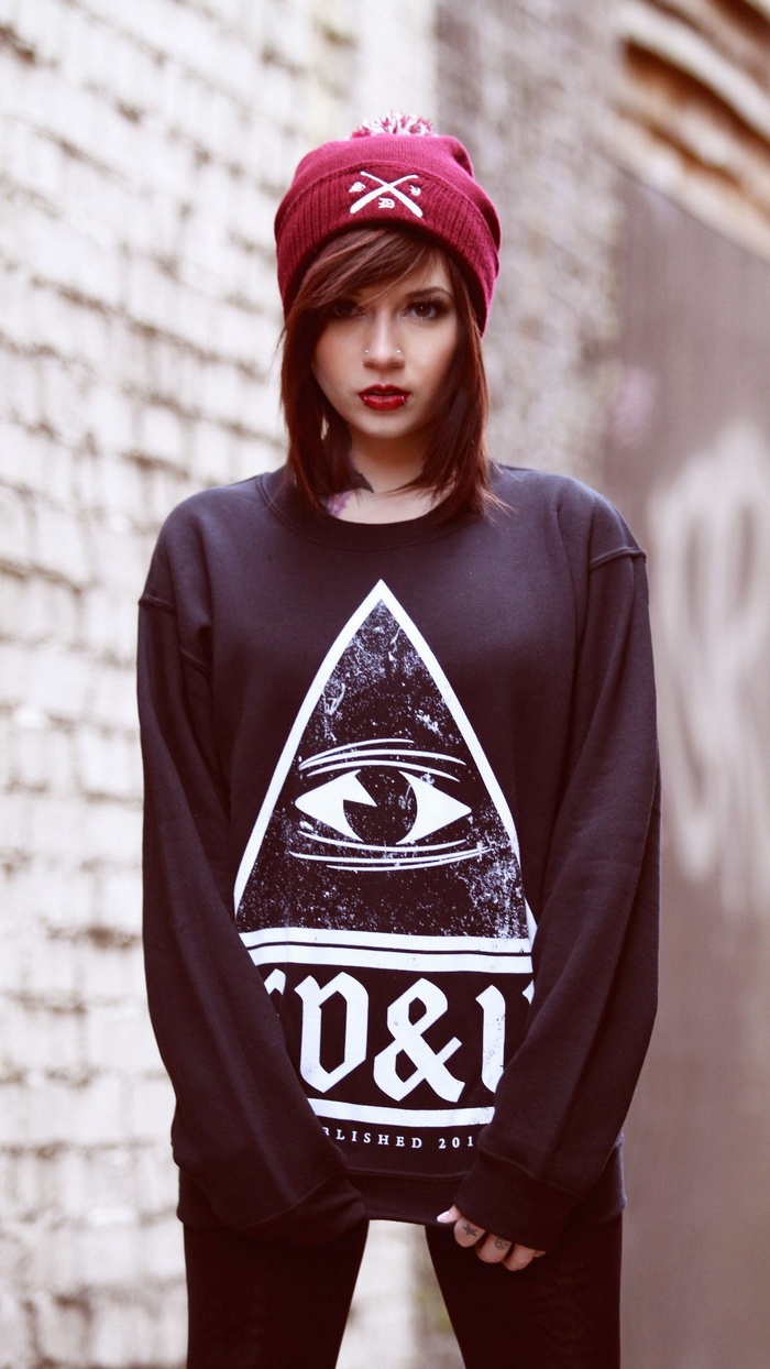 Woman wearing a beanie and a graphic sweatshirt