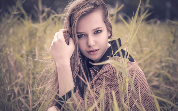 Woman sitting in tall grass