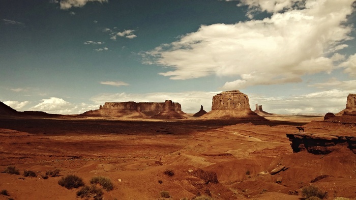 Monument Valley desert landscape with rock formations and a horse rider