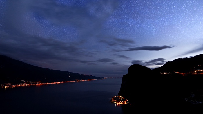 Night landscape with stars over a lake and mountains