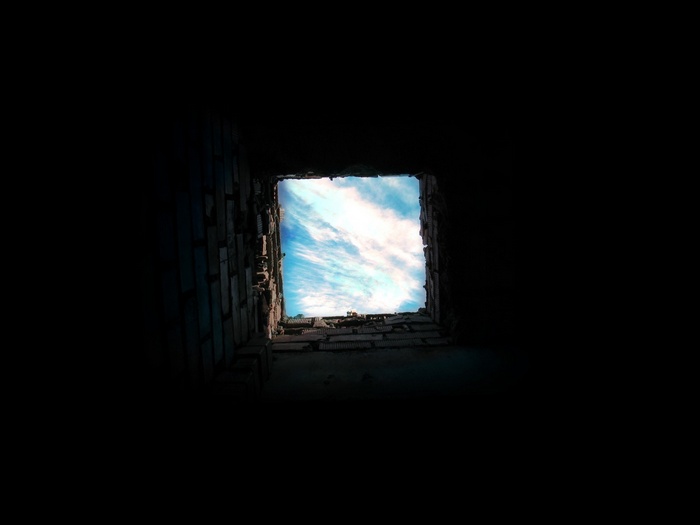 Worm's eye view of clouds through a brick opening