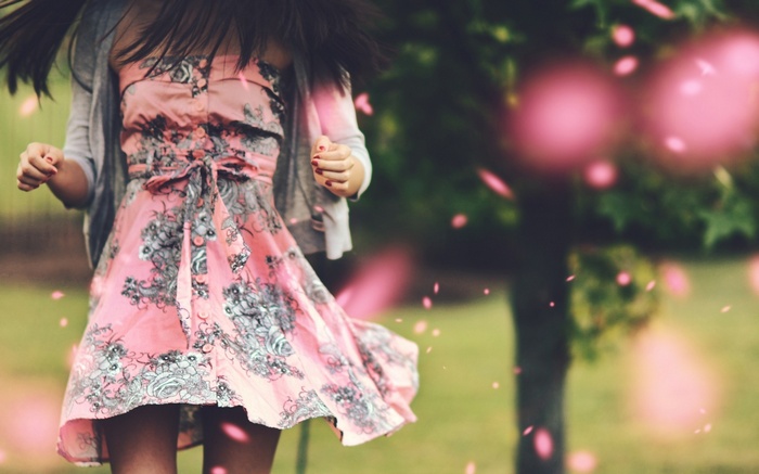 Woman in a pink floral dress walking outdoors