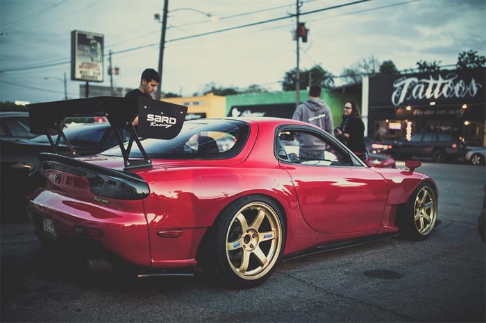 Red Mazda RX-7 with a large rear spoiler