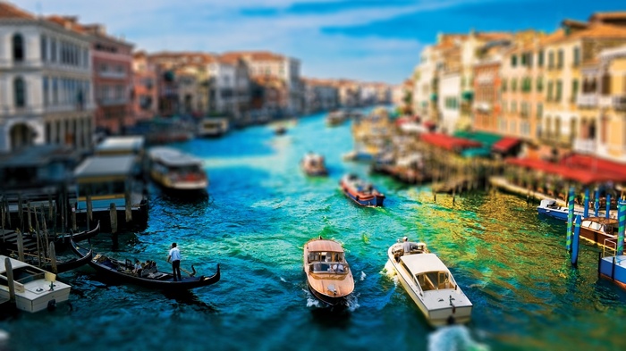 Venice canal with boats and buildings, tilt-shift effect